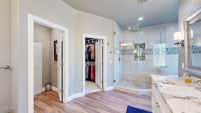 bathroom with vanity, hardwood / wood-style floors, and a shower with door