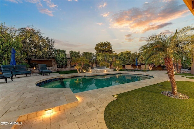 pool at dusk with a patio, a yard, and a jacuzzi