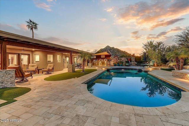 pool at dusk with a patio area