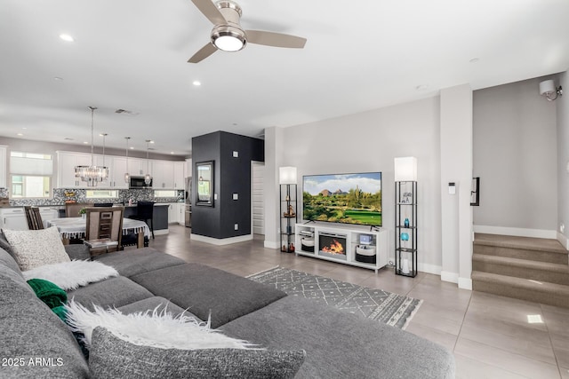 living room featuring tile patterned flooring, ceiling fan, baseboards, and recessed lighting