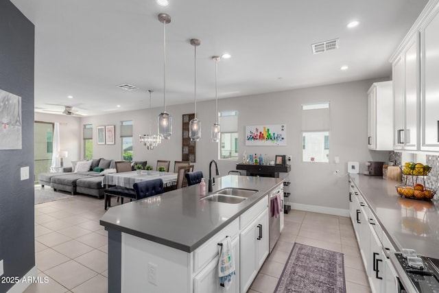 kitchen with a sink, stainless steel dishwasher, light tile patterned floors, white cabinetry, and recessed lighting