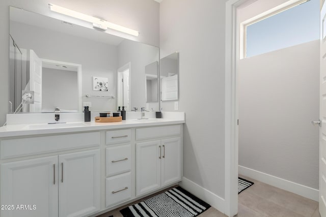bathroom featuring double vanity and baseboards