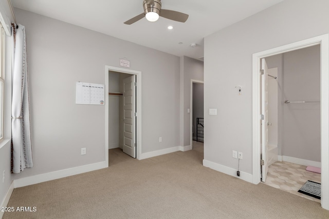 unfurnished bedroom with a walk in closet, a closet, light carpet, recessed lighting, and baseboards