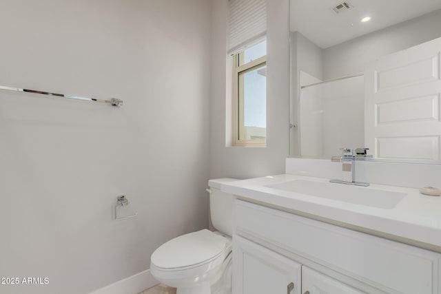 bathroom featuring toilet, baseboards, and vanity