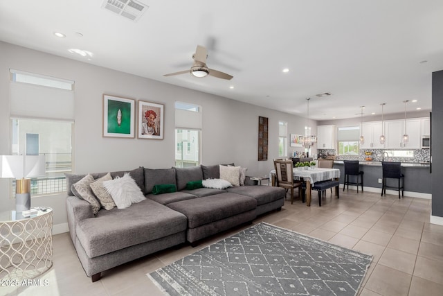 living area featuring recessed lighting, light tile patterned floors, a ceiling fan, and baseboards