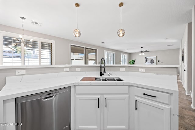 kitchen with white cabinetry, dishwasher, sink, light stone countertops, and a healthy amount of sunlight