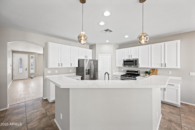 kitchen with pendant lighting, an island with sink, and appliances with stainless steel finishes