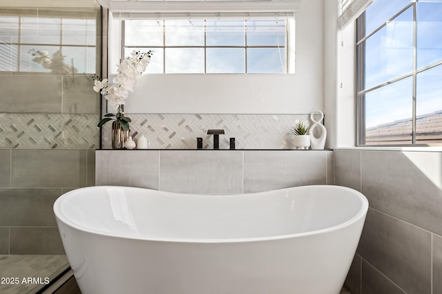 bathroom featuring tile walls and a bathing tub