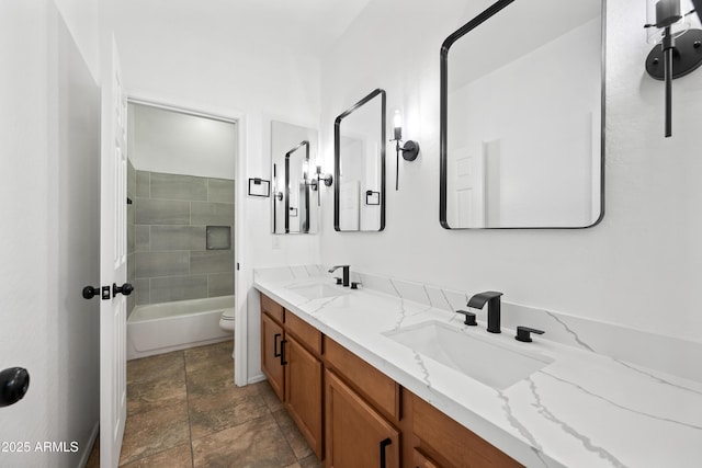 full bathroom featuring tiled shower / bath, vanity, and toilet