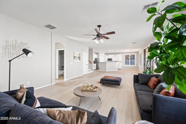 living room with ceiling fan and light hardwood / wood-style flooring