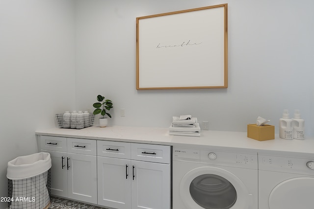 clothes washing area featuring cabinets and separate washer and dryer