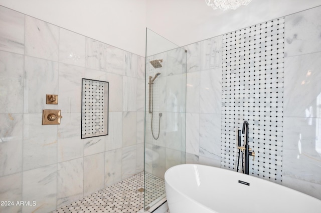 bathroom featuring tile walls, walk in shower, and a soaking tub