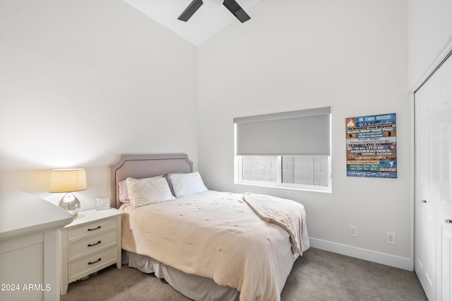 bedroom with lofted ceiling, a closet, baseboards, ceiling fan, and carpet