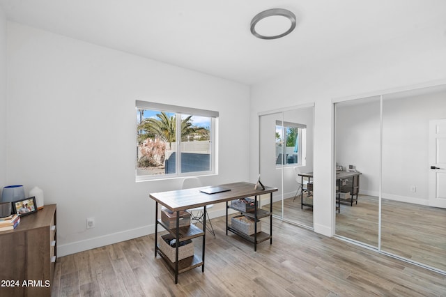 office space featuring baseboards and light wood finished floors