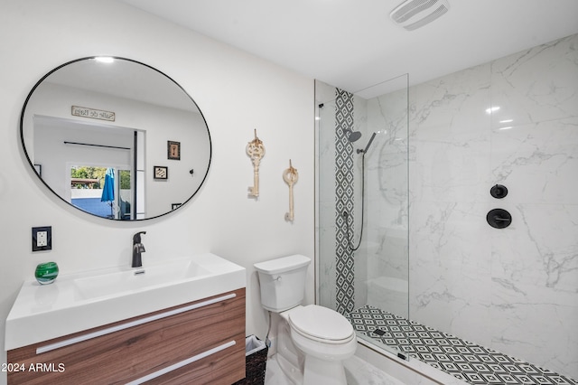 full bathroom with toilet, vanity, a marble finish shower, and visible vents