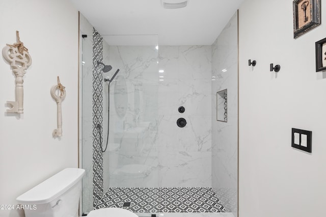 full bath featuring a marble finish shower and toilet