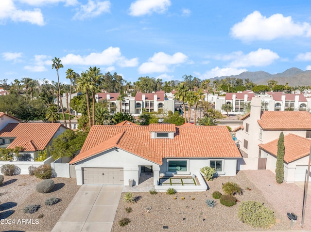 view of front of home featuring a tiled roof, concrete driveway, stucco siding, and a residential view