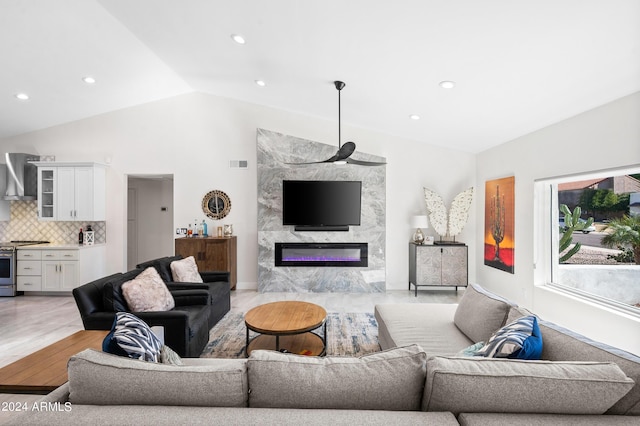 living room featuring visible vents, light wood-type flooring, recessed lighting, vaulted ceiling, and a premium fireplace