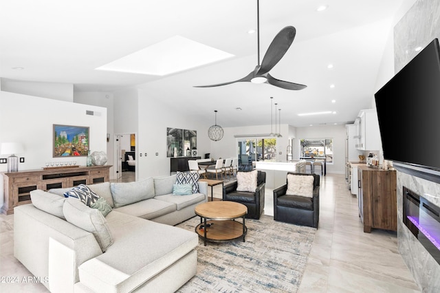 living room featuring a glass covered fireplace, recessed lighting, a ceiling fan, visible vents, and lofted ceiling