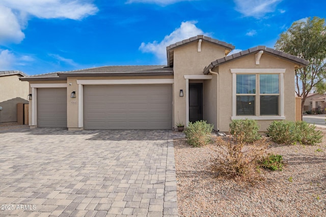 ranch-style home featuring decorative driveway, an attached garage, and stucco siding