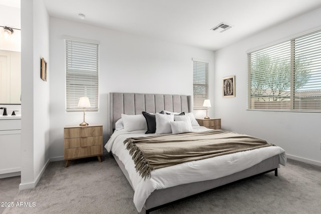 bedroom featuring visible vents, a sink, baseboards, and carpet floors