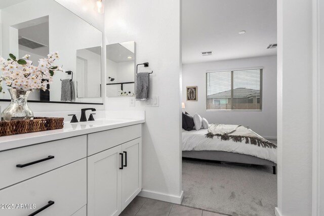 bathroom featuring tile patterned flooring, visible vents, ensuite bath, and vanity