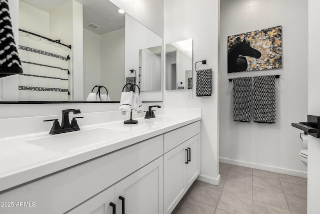 bathroom featuring tile patterned floors, baseboards, and a sink