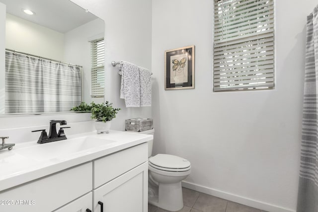 bathroom featuring tile patterned flooring, toilet, vanity, and baseboards