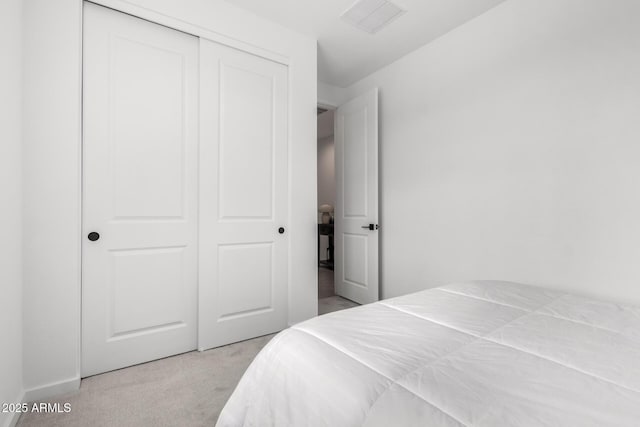 carpeted bedroom featuring visible vents and a closet