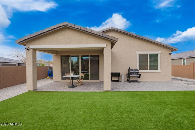 back of house featuring a patio, a lawn, a fenced backyard, and stucco siding