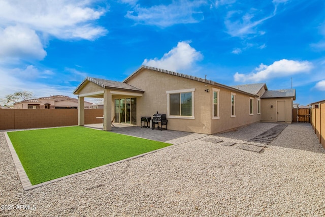 rear view of house featuring a patio area, stucco siding, a yard, and a fenced backyard