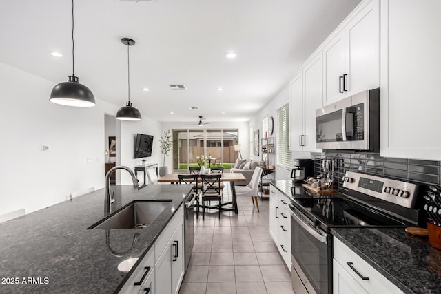 kitchen with visible vents, backsplash, appliances with stainless steel finishes, white cabinetry, and a sink