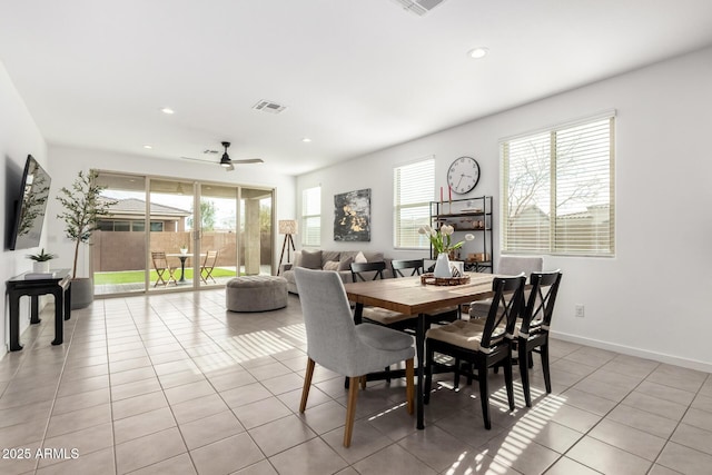 dining space featuring light tile patterned floors, visible vents, plenty of natural light, and baseboards