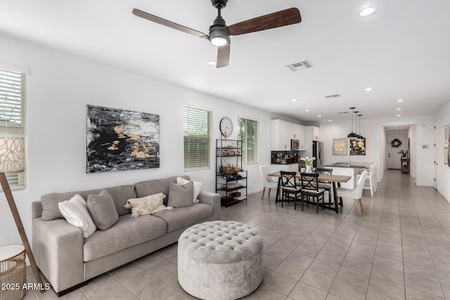 living room featuring light tile patterned flooring, recessed lighting, visible vents, and a wealth of natural light