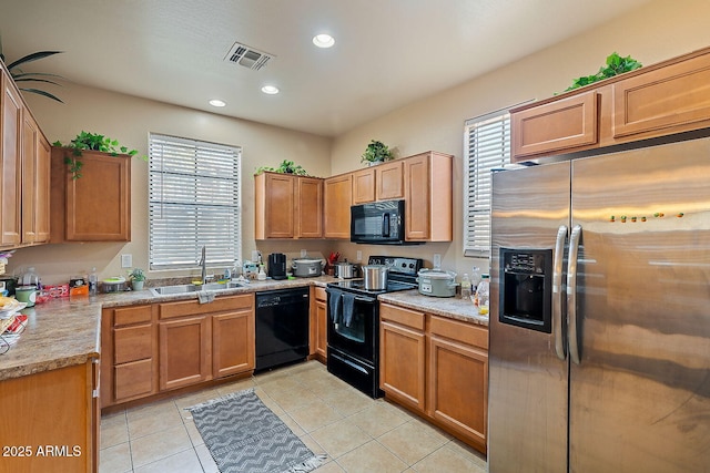 kitchen featuring light tile patterned flooring, sink, a wealth of natural light, and black appliances