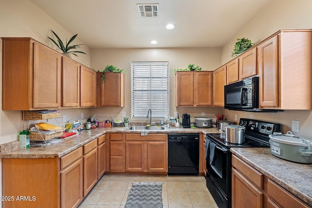 kitchen featuring sink, black appliances, and light tile patterned flooring