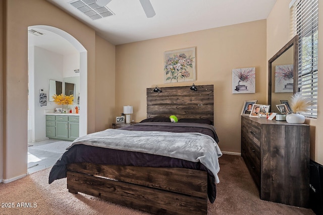 carpeted bedroom with ceiling fan and ensuite bathroom