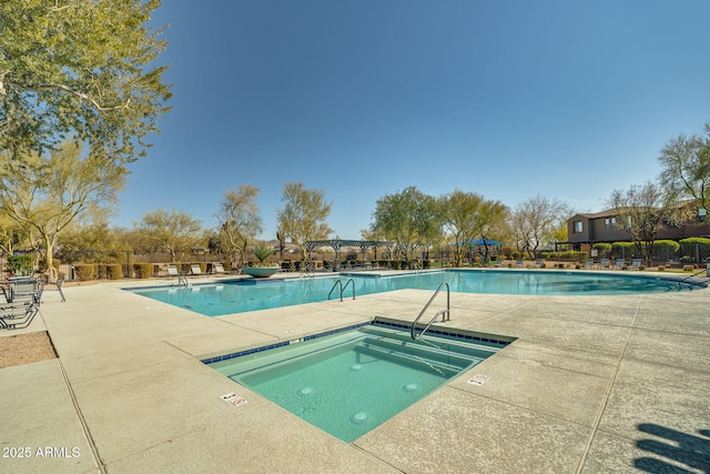 view of swimming pool with a hot tub and a patio area