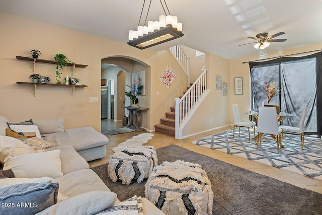 tiled living room featuring ceiling fan with notable chandelier