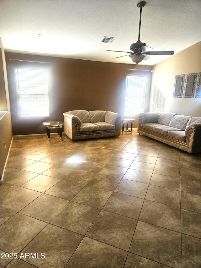 interior space featuring ceiling fan and dark tile patterned flooring