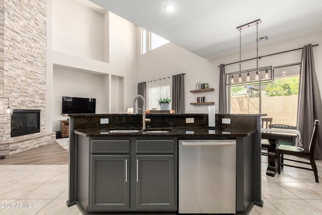 2030 W Whisper Rock Trl, Phoenix, AZ 85085 - kitchen with stainless steel dishwasher, open floor plan, dark stone countertops, a kitchen island with sink, and gray cabinetry
