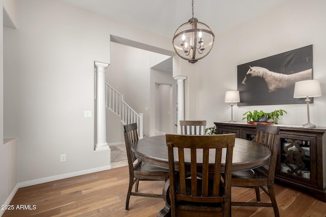 2030 W Whisper Rock Trl, Phoenix, AZ 85085 - dining room with decorative columns, a chandelier, light wood-style floors, and stairs