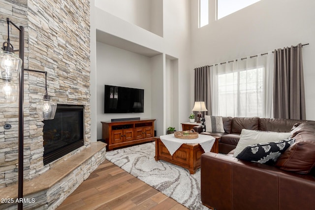 2030 W Whisper Rock Trl, Phoenix, AZ 85085 - living room featuring wood finished floors, a stone fireplace, and a high ceiling