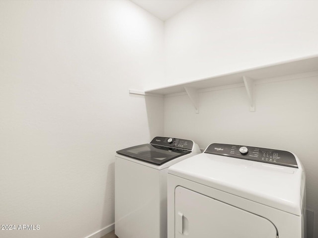 laundry room with laundry area, separate washer and dryer, and baseboards