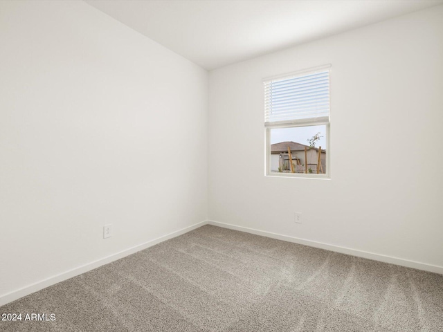 carpeted spare room with baseboards