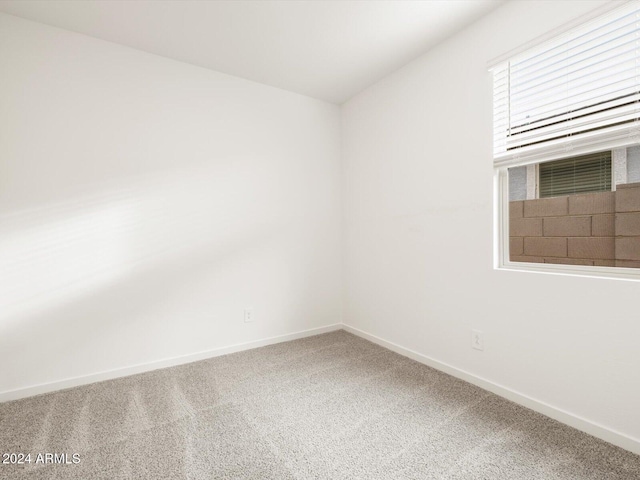 unfurnished room with baseboards and carpet