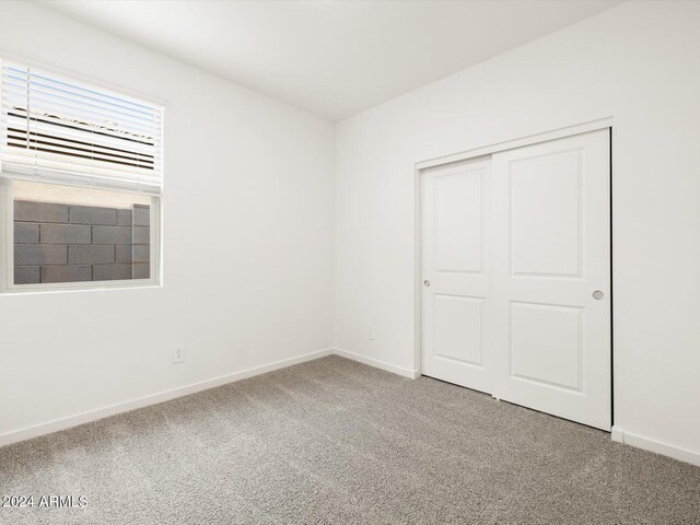 unfurnished bedroom with a closet, baseboards, and carpet