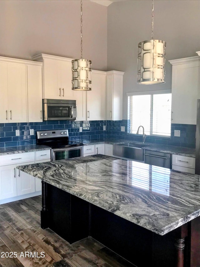 19365 N 28th St, Phoenix, AZ 85050 - kitchen featuring appliances with stainless steel finishes, a high ceiling, a sink, white cabinetry, and a center island