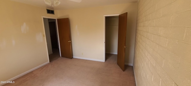 unfurnished bedroom featuring a closet and light colored carpet