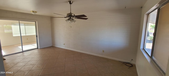 unfurnished room with a healthy amount of sunlight and brick wall